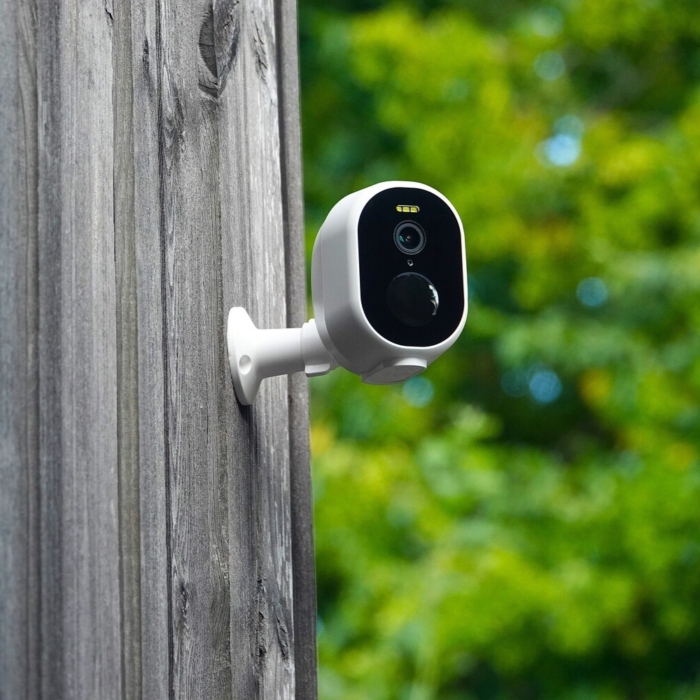 DanGear 4MP overvågningskamera med batteri tæt på, monteret højt oppe udendørs på en husfacade af træ