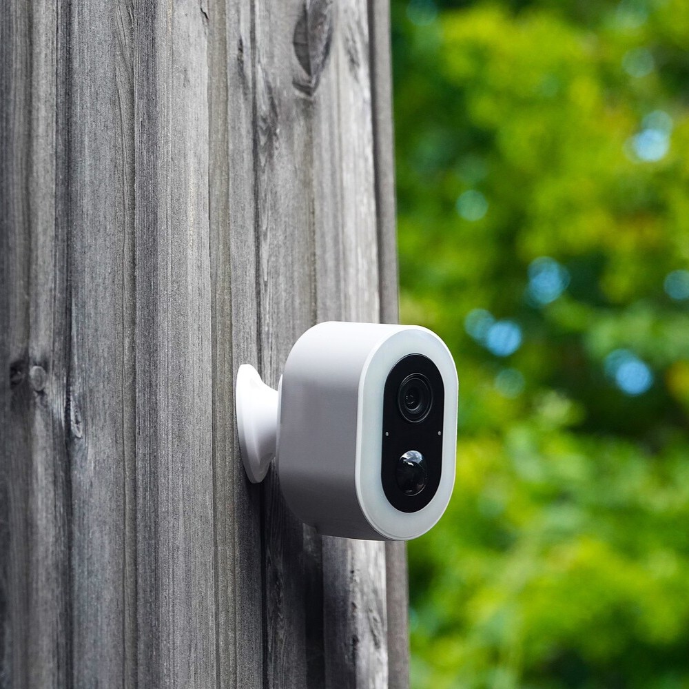 DanGear 4MP overvågningskamera med stort batteri tæt på, monteret udendørs på husfacade af træ