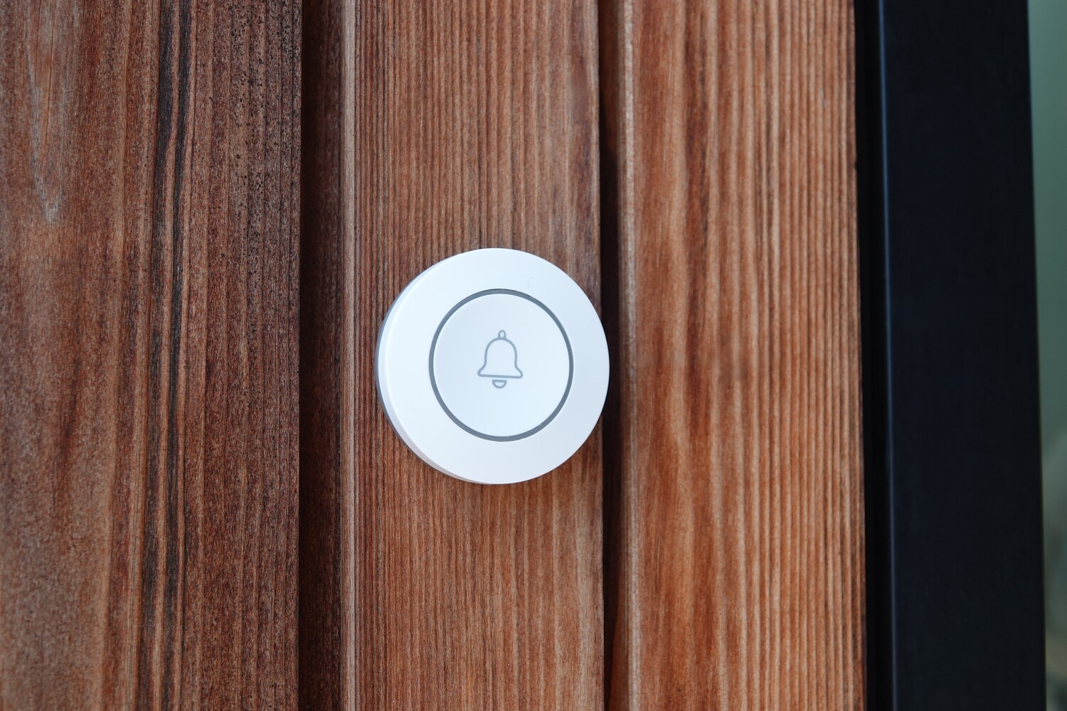 DanGear mini ringeklokke tæt på, monteret på husfacade af træ udendørs