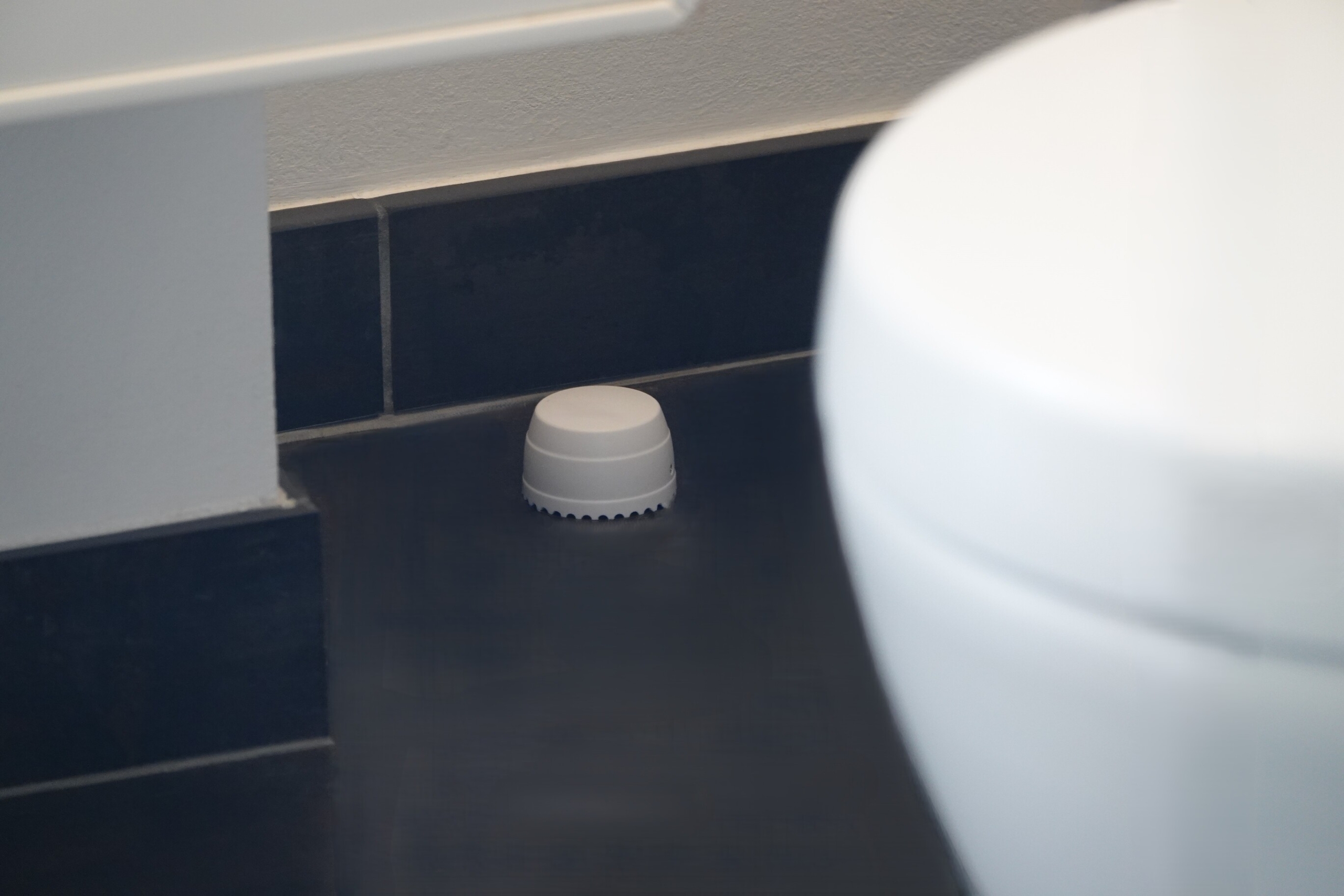 dangear vandsensor på gulvet ved siden af toilet på badeværelse