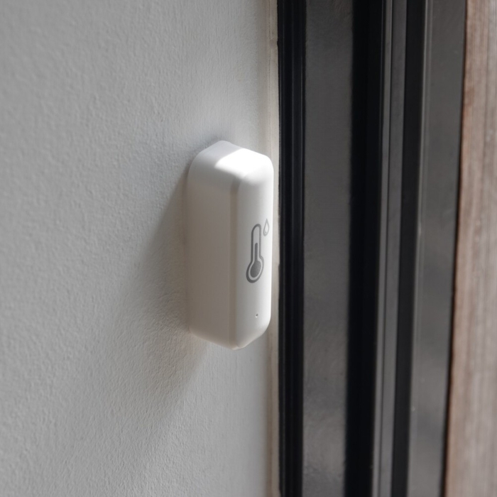 WiFi termometer og fugtighedsmåler tæt på fra siden, monteret på væg