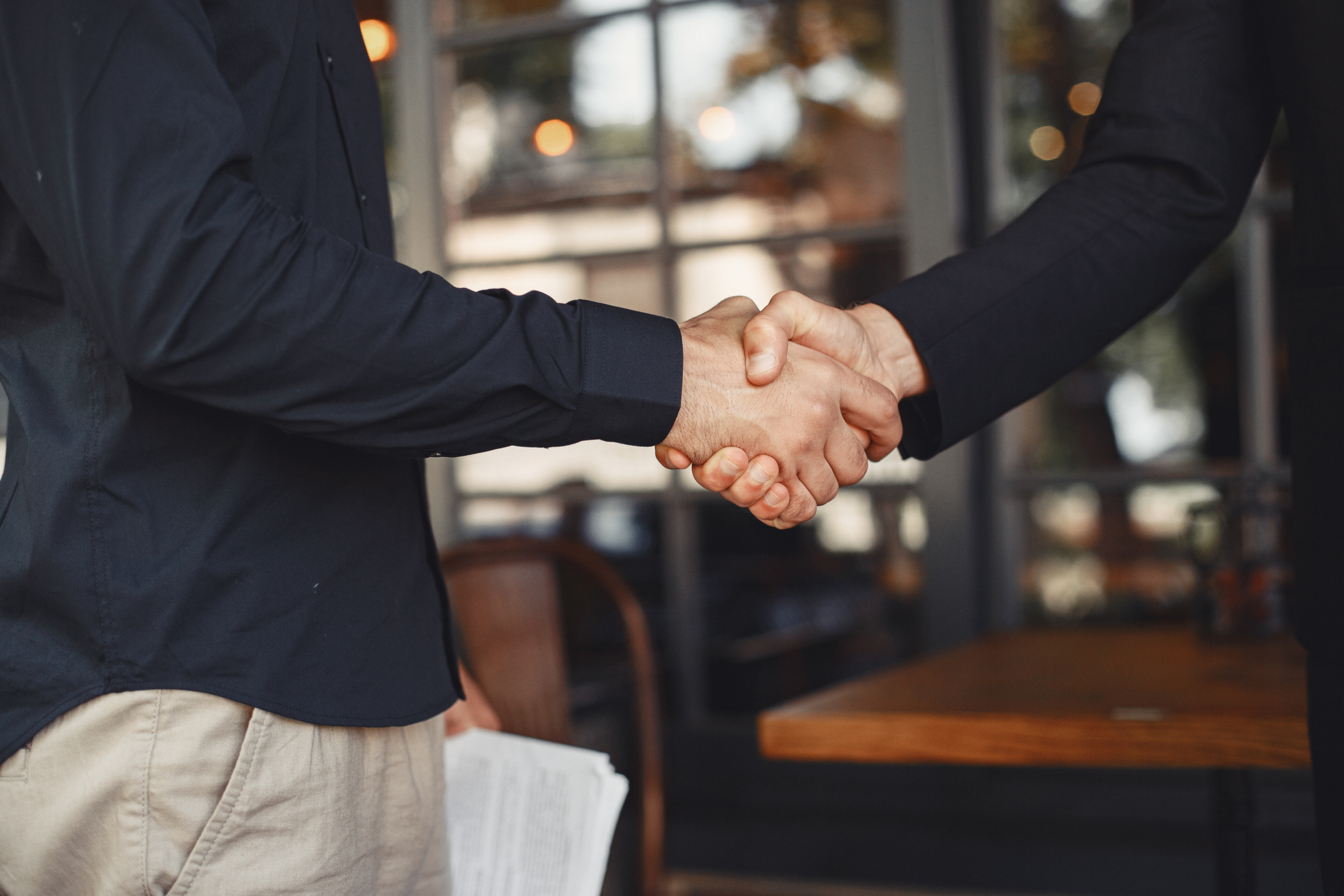 Portrait of cheerful young manager handshake with new employee. Nødkald til ældre og udsatte med gratis app til smartphone